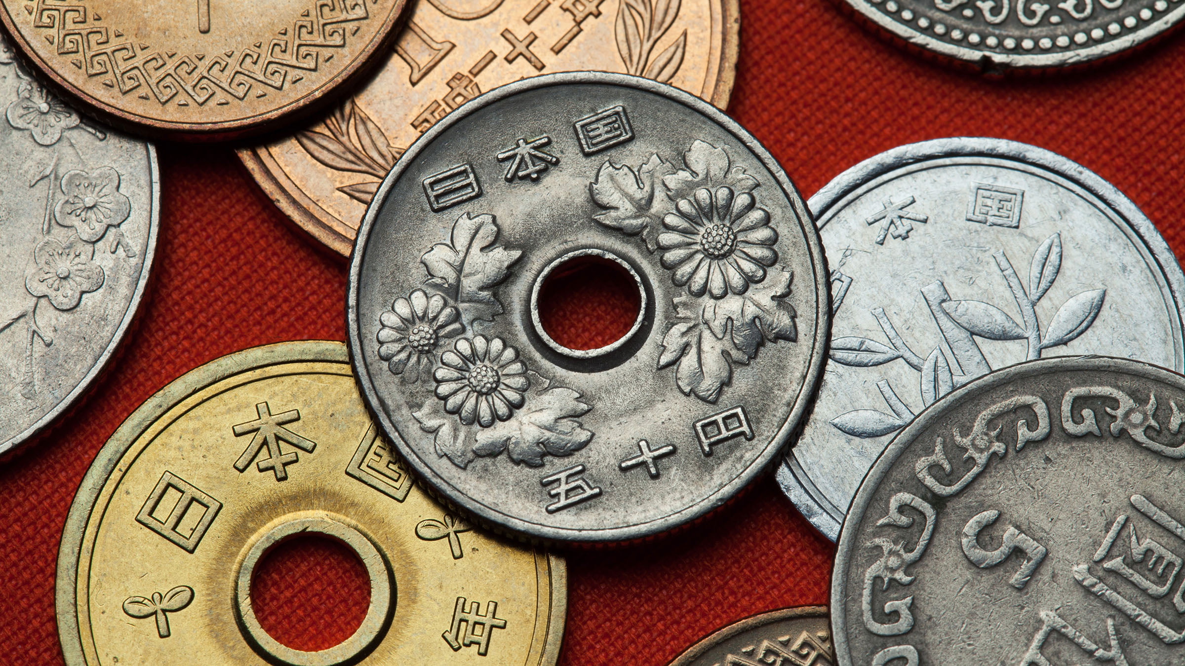 日本円の硬貨が積まれた様子 ― 利上げと預金金利、インフレによる目減りのイメージ